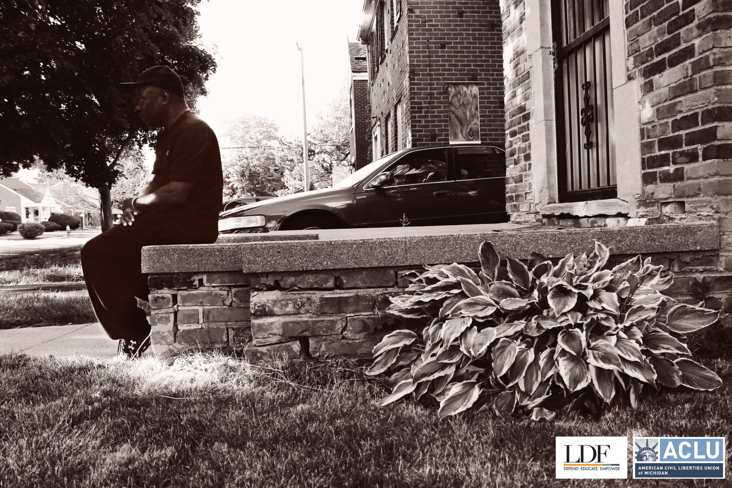 Walter Hicks sits on his stoop in front of his house looking towards the street.