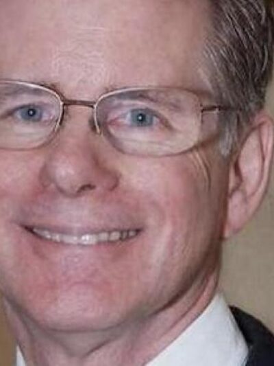 Judge Steven Rhodes wears wide-framed glasses and has salt and pepper hair. He smiles at the camera.