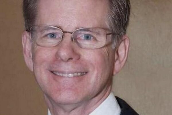 Judge Steven Rhodes wears wide-framed glasses and has salt and pepper hair. He smiles at the camera.