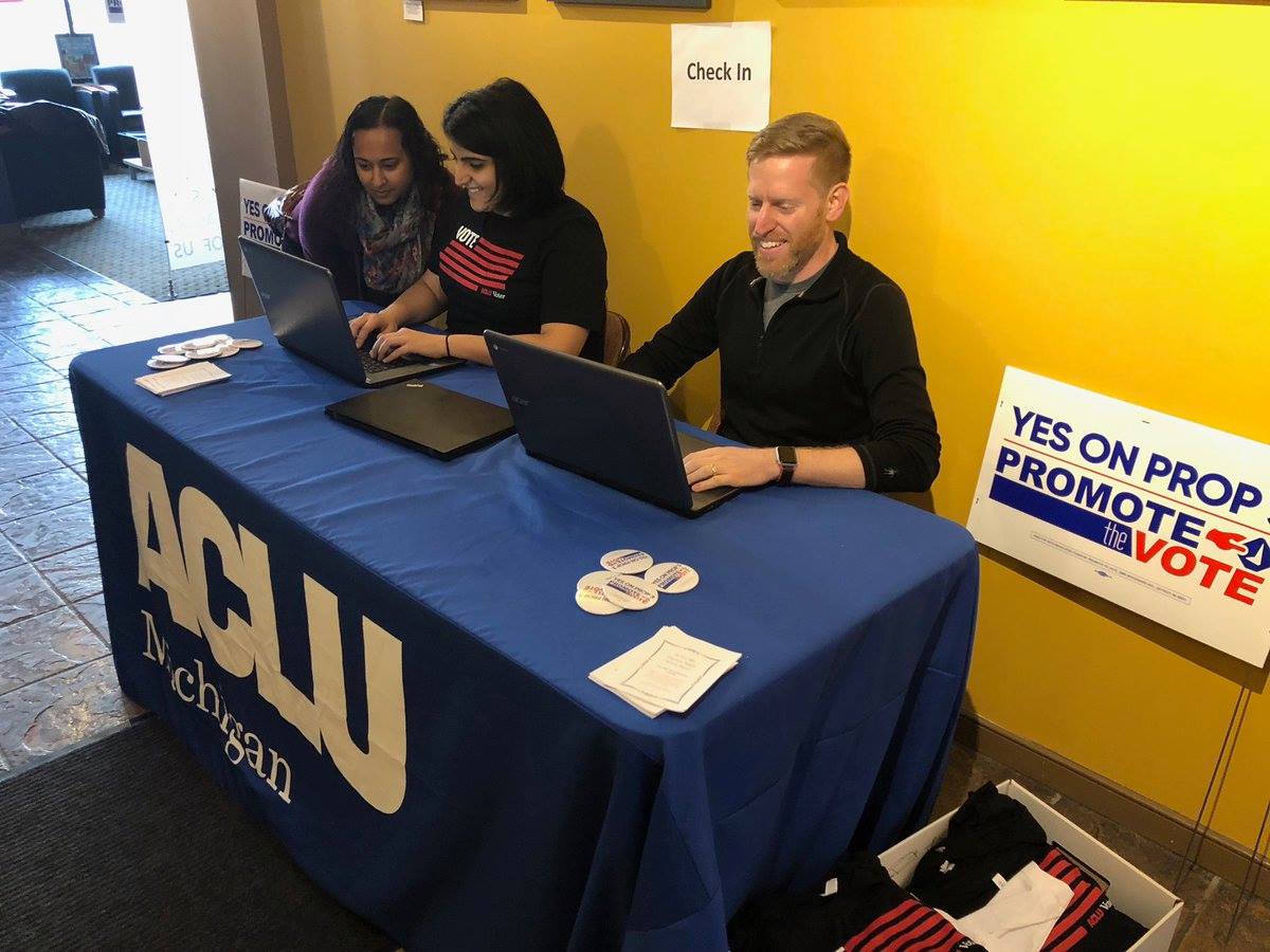 Three volunteers at sign-in table at ACLU of Michigan