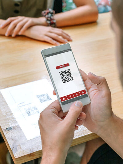 A man uses his phone to scan restaurant QR code on table