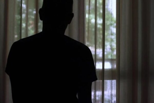 silhouette of anoymous person looking out window