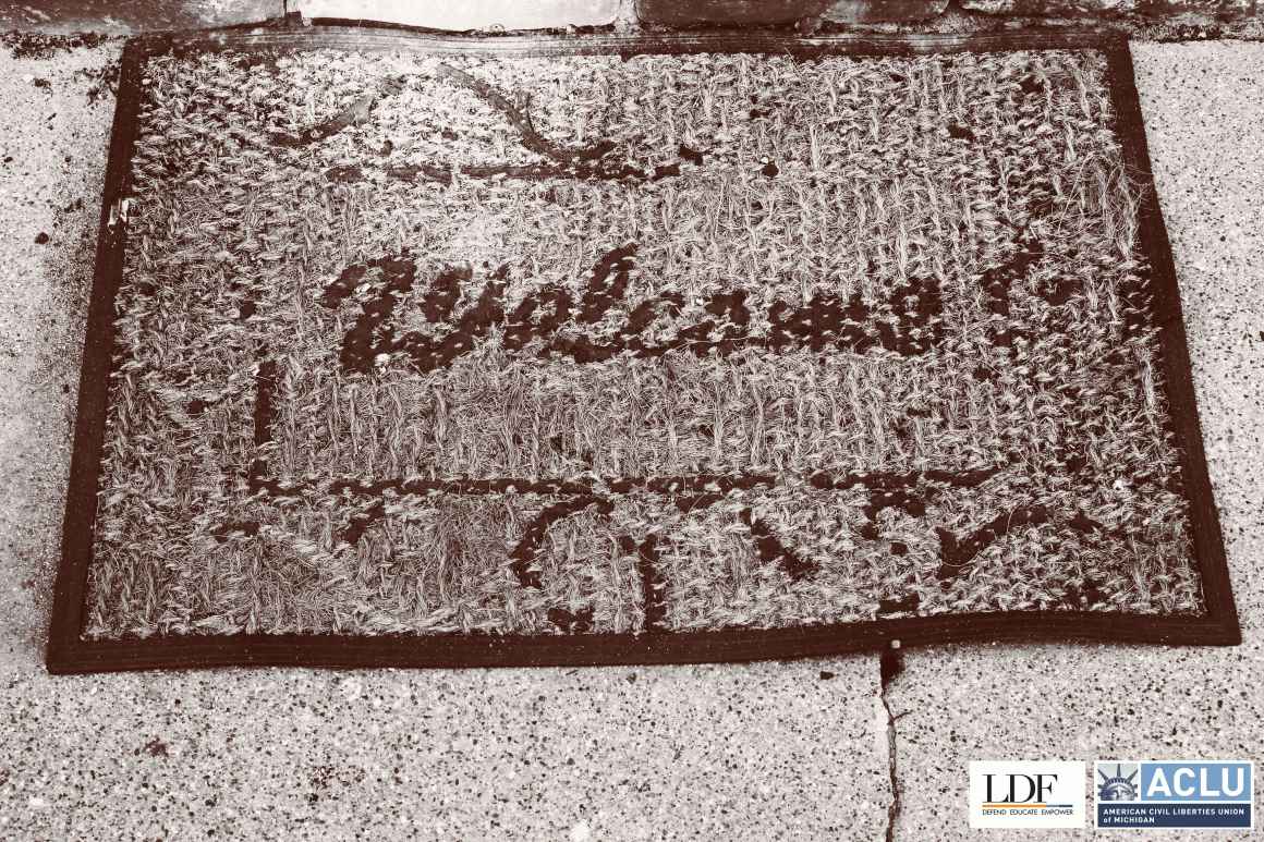 A worn out welcome mat on concrete