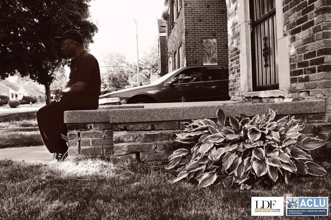 Walter Hicks sits on his stoop in front of his house looking towards the street. 