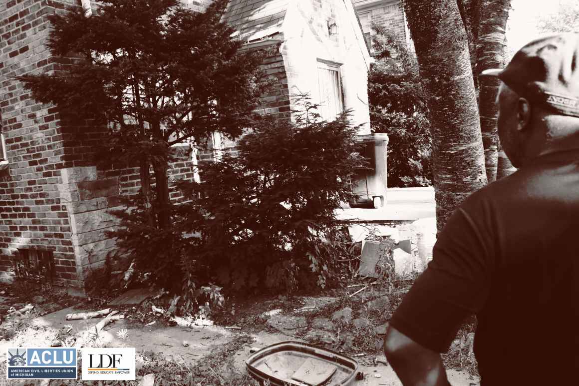 Walter Hicks looks at the left side of his house, where there is a tree, trash, and bits of concrete