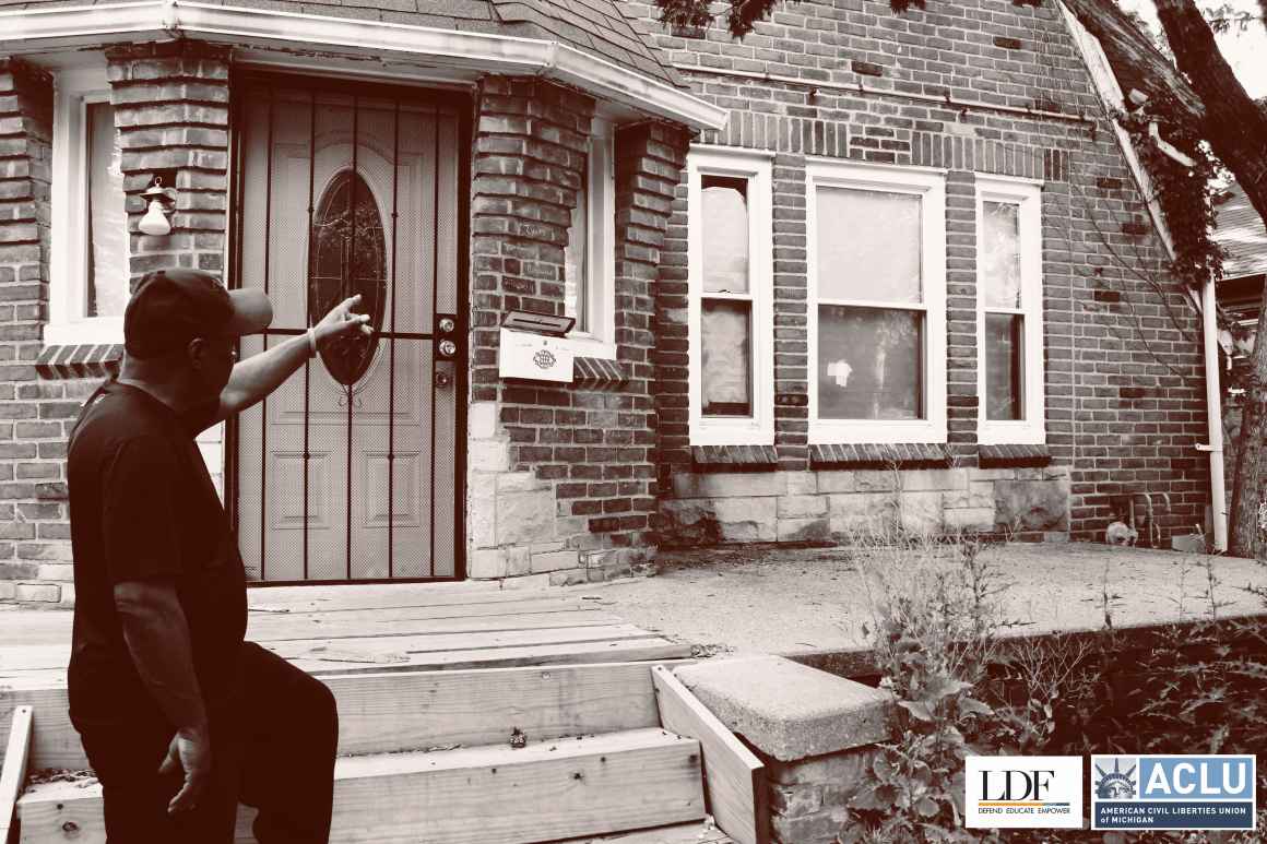 Walter Hicks points towards his foreclosed house. 