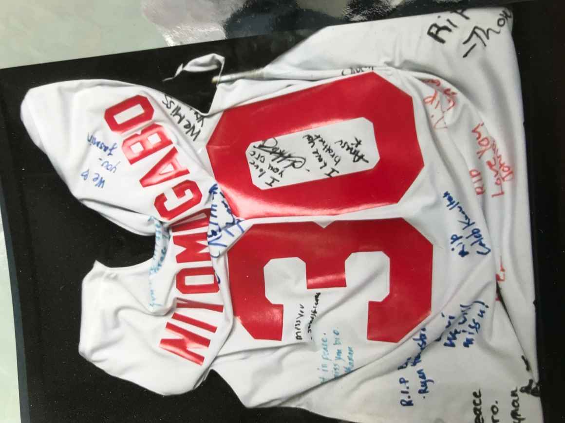Djibril Niyomugabo's basketball jersey signed with messages from his teammates. It was hung at funeral.
