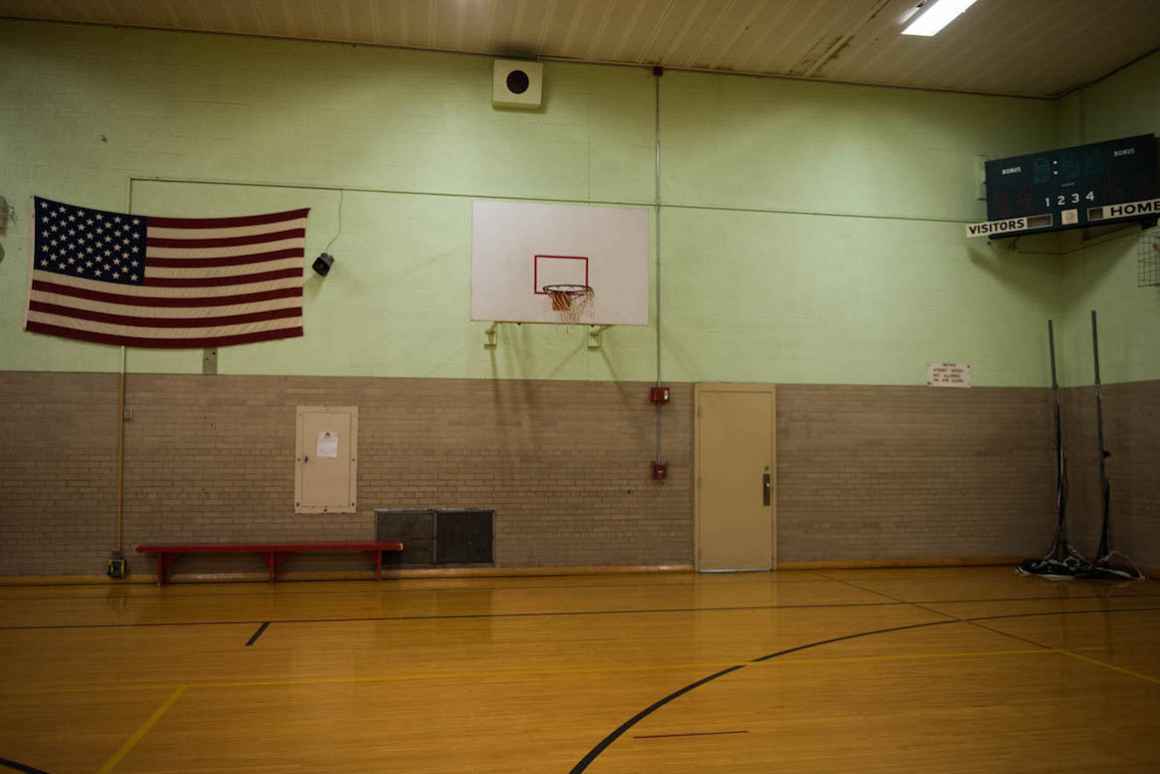 The gym at Nelson Elementary school features old basketball hoops that are not safeguarded from detaching from the wall if a child hangs from the rim