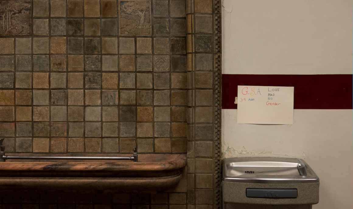 Plaster cracks around the wall-mounted base of a water fountain at Muskegon High.