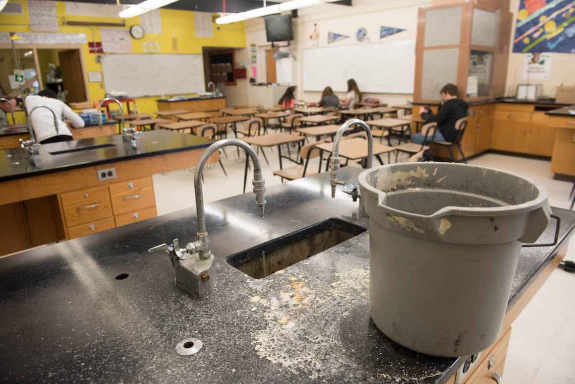 In the high school chemistry lab, a roof leak has made one of the lab stations unusable.