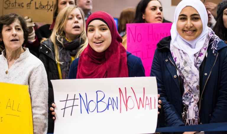 woman wearing hijab holds sign that says &quot;No Ban, No Wall&quot;