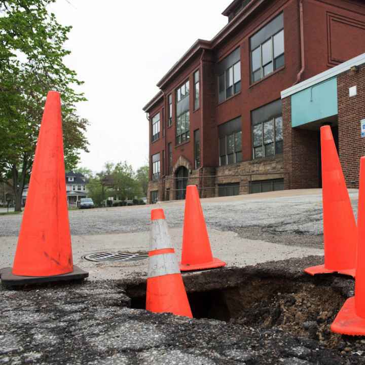 Gaping sinkholes such as this one outside the J Building of Muskegon High constitute the sort of overlooked capital repairs that many tax-poor districts cannot afford to make.