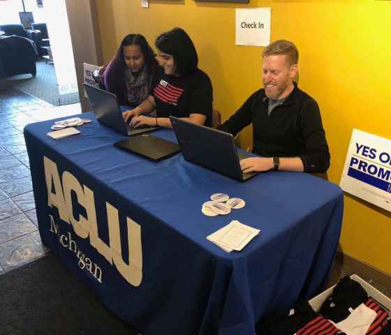 Three volunteers at sign-in table at ACLU of Michigan